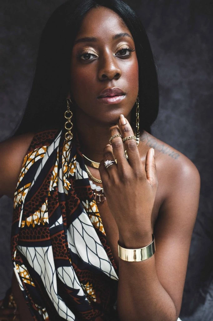 A woman in an african print dress posing for a photo.